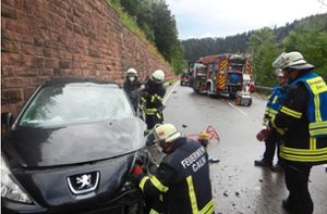 Feuerwehrleute öffnen die Fahrertür eines der am Unfall beteiligten Autos. Foto: Weißenmayer