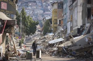 Ein Mann geht an zerstörten Gebäuden von Antakya in der Türkei  entlang. (Archivbild) Foto: dpa/Unal Cam