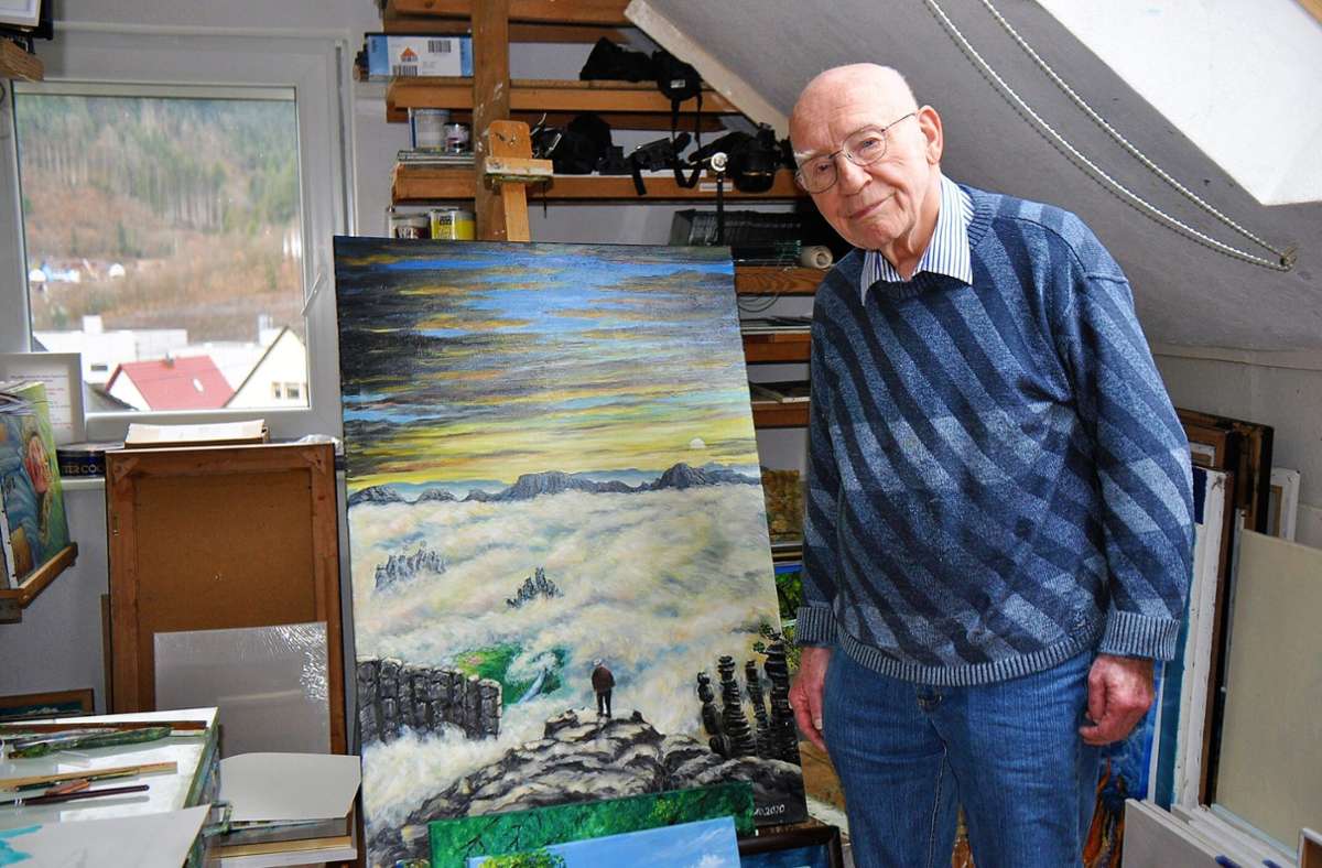Paul Armbruster vor einem Bild, das ihn  an der Bergklippe im Sandsteingebirge zeigt  – bei der Wanderung   war er  83 Jahre alt. Foto: Rahmann