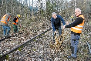 Landrat Helmut Riegger (Mitte) packt selbst mit an, um die alte Schwarzwaldbahn-Strecke von Gestrüpp zu befreien. Foto: Klormann