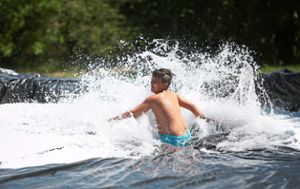 Das macht Spaß: Bei der Hitze kommt die Wasserrutsche im Ferienprogramm gut an. Foto: Wagner Foto: Schwarzwälder Bote