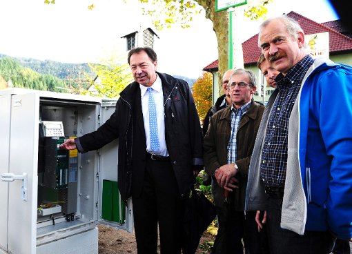 Bürgermeister Siegfried Eckert nimmt im Beisein einiger Gemeinderäte die neue Fußgängerampel offiziell in Betrieb. Foto: Gräff