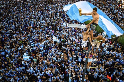 In Buenos Aires brechen nach dem spektakulären WM-Sieg der Albiceleste alle Dämme. Einige Wagemutige erklimmen die Straßenlampen. Foto: /