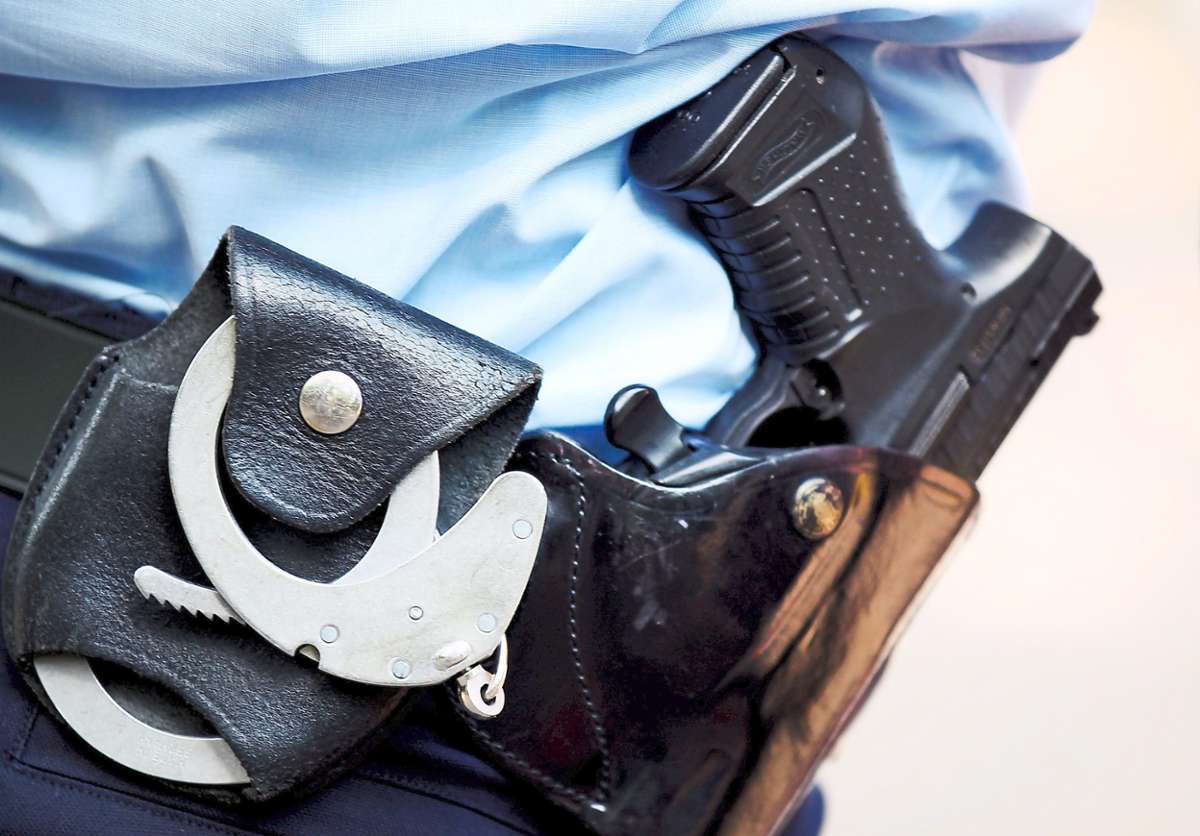Handschellen am Gürtel eines Polizisten. (Symbolfoto) Foto: Berg