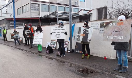 Mit Plakaten und coronakonform maskiert: Bei der Einfahrt zum Balinger Schlachthof stehen Aktivisten von Rottenburg Animal Save.  Foto: Ungureanu