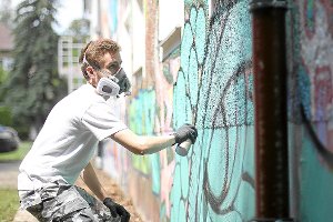 Mit einem Mundschutz macht sich dieser Graffiti-Künstler ans Werk.  Foto: Mader