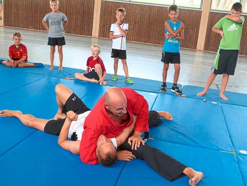 So, der kann nichts mehr anstellen: Tai-Jitsu-Karate-Trainer Ingo Huber legt Carsten Stehle auf die Matte. Zum Vergnügen der Kinder, die sich von den beiden beim Haigerlocher Ferienspaß Grundtechniken der Selbstverteidigung zeigen ließen. Foto: Kost Foto: Schwarzwälder-Bote