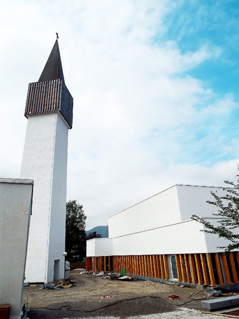 Der neue Kirchenbau passt stilistisch zu dem einzeln stehenden Turm, der vom Brand am 13. März 2011verschont worden war.