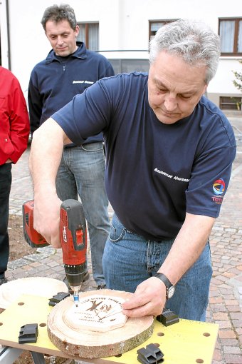 Hermann Schmider von der Baumgilde bohrt die Platten mit den Brandzeichen auf die Narrenbaumscheiben. Foto: Agüera-Oliver