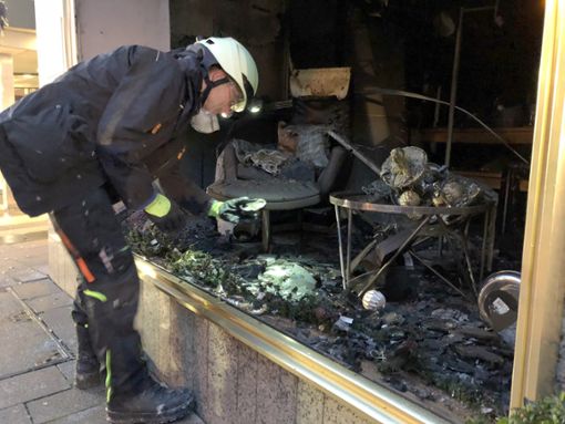 Ein Feuerwehrmann begutachtet den Schaden in dem Ladengeschäft in Friedrichshafen. Es brannte völlig aus. Foto: dpa