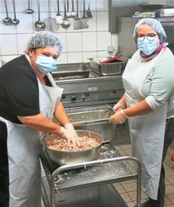 Petra Heini (links) und Steffi Schwarzeit sind voll im Element, 560 Portionen Wurstsalat müssen zubereitet und im genauen Zeitfenster ausgeliefert werden. Foto: Preuß Foto: Schwarzwälder Bote