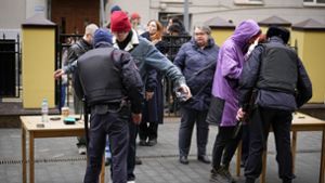 Wähler stehen am Sonntag um 12 Uhr  in Moskau  Schlange, um von der Polizei kontrolliert zu werden. Die russische Opposition hatte zu Protesten aufgerufen. Foto: dpa/Alexander Zemlianichenko
