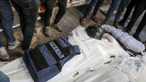Eine Weste mit der Aufschrift «Presse» und ein Helm liegen auf dem Leichnam eines Journalisten. Foto: dpa/Abed Rahim Khatib