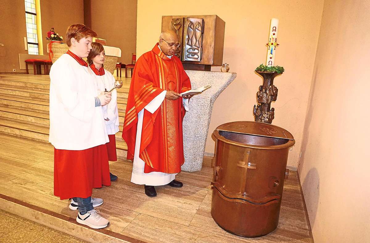 Pater Paul Kalarickal weihte das Taufbecken in der katholischen Kirche in Schömberg neu. Tim (links) und Koen van Veen waren als Messdiener im Einsatz. Foto: Krokauer