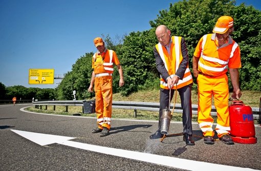 Minister in Aktion: Im vergangenen Sommer markierte Hermann bei Esslingen den ersten Richtungspfeil auf einer Autobahnauffahrt Foto: Max Kovalenko