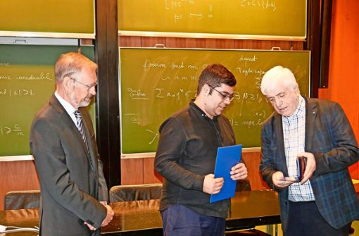 Gerhard Huisken (MFO, rechts) und Klaus Hulek (Oberwolfach-Stiftung, links) überreichten Vesselin Dimitrov den Preis. Foto: Dorn