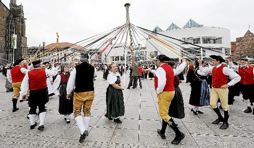 So sieht ein Rekordversuch aus: Die Tanzpaare des Schwäbischen Albvereins wirbeln auf dem Ulmer Münsterplatz um die Maibäume. Foto: Puchner