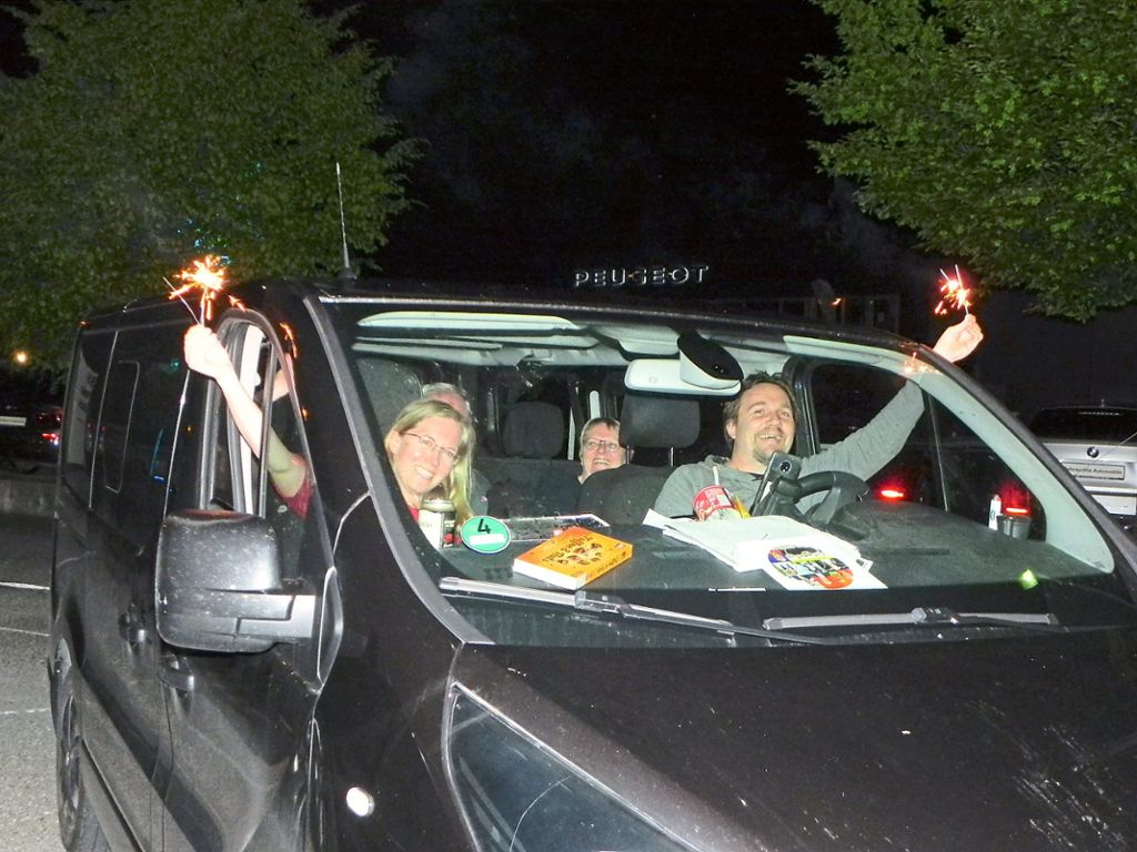 Diese Fans halten während des Konzerts brennende  Wunderkerzen aus den Autofenstern. Foto: Bäurle