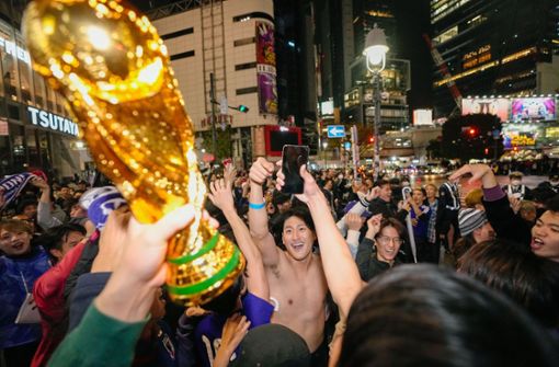In Tokio feiern Menschen ohne Maske den Sieg der japanischen Elf gegen Deutschland. In China reibt man sich ob solcher Bilder die Augen. Foto: dpa/Kyodo News