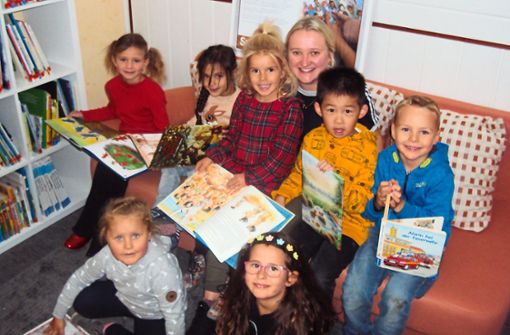 Die Fachkraft zur Sprachförderung der Sprach-Kita St. Josef Stefanie Schmidt und die Kinder freuen sich über die neue Bibliothek, welche mithilfe der Fördergelder errichtet wurde. Foto: Simon Bäurer