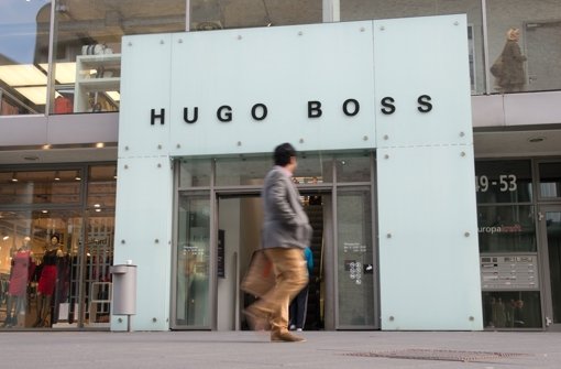 Ein Mann geht in Metzingen am Eingang des Hugo Boss-Fabrikverkaufs vorbei. Foto: dpa