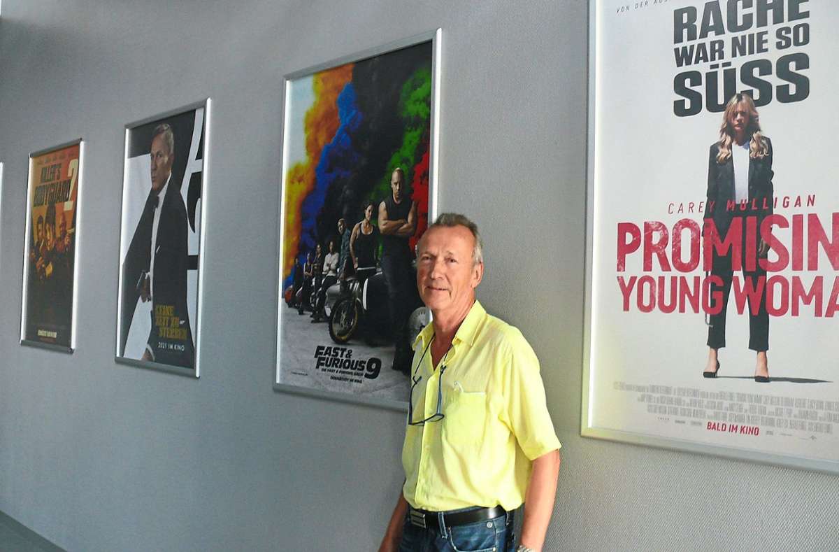 Hans Müller steht vor Plakaten, die die Filme ankündigen, die nach dem Neustart des Bali-Kino-Palasts in den kommenden Monaten zu sehen sind.