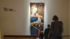 Besucher der  Pressevorbesichtigung gehen an einem Plakat das einen Ausschnitt des Gemäldes „Madonna des Bürgermeisters Jacob Meyer zum Hasen“ (1526 - 1528, Hans Holbein dem Jüngeren) zeigt, vorbei. Das Städel Museum Frankfurt zeigt „Holbein und die Renaissance im Norden“. Foto: dpa/Andreas Arnold