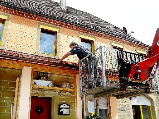 Manfred Schick steht auf einer Plattform und tauscht kaputte Dachziegeln mit neuen aus. Gerade in Binsdorf war das gestern kein ungewohntes Bild, denn am Dienstag hatten die großen Hagelkörner viele Dächer beschädigt.   Foto: Hauser Foto: Schwarzwälder-Bote