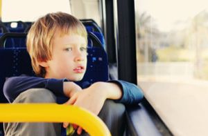 Eine Junge sitzt lässig im Bus. Ist die Fahrt im Schulbus sicher? Foto: dubova - stock.adobe.com