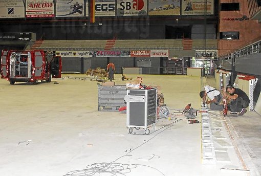 Arbeiter gehen aufs Eis: Die Schwenninger Helios-Arena bekommt neue Banden. Foto: Direvi