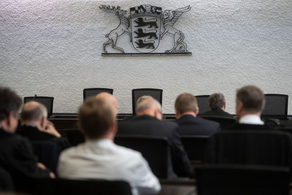 Angeklagte und Verteidiger sitzen vor der Urteilsverkündung im Prozess gegen ehemalige Mitarbeiter von Heckler & Koch in einem Gerichtssaal im Landgericht Stuttgart. Foto: Marijan Murat/dpa