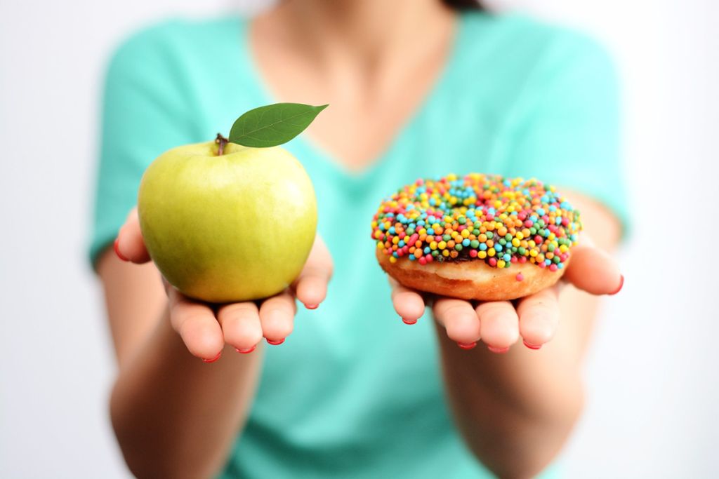 Lieber einen Apfel statt eines Donuts essen? In der Fastenzeit darf ausprobiert werden. Foto: © adrian_ilie825  – stock.adobe.com