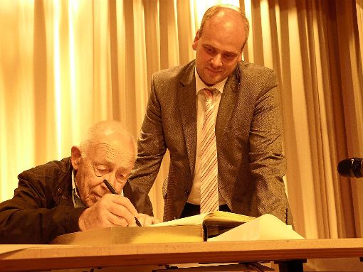 Unter Anleitung von Schömbergs Bürgermeister Matthias Leyn trägt sich Heiner Geißler in das Goldene Buch der Glücksgemeinde ein. Foto: Eitel Foto: Schwarzwälder-Bote
