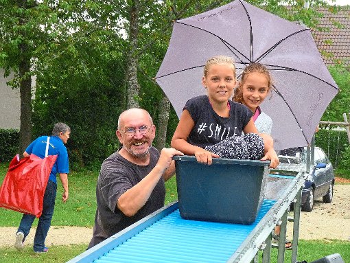 Die Rollenrutsche funktioniert auch mit Regenschirm super, wenn die kleinen Fahrgäste so freundlich von Reinhard Isak angeschoben werden. Fotos: Lendle Foto: Schwarzwälder-Bote