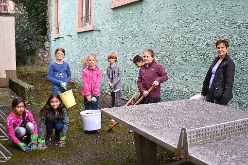 Mit vereinten Kräften sammeln die Kinder des Jugendtreffs Müll und befreien den Asphalt vom Moos. Foto: Kiolbassa Foto: Schwarzwälder-Bote
