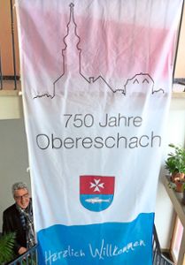 Mit einem extra entworfenen Banner will Ortsvorsteher Klaus Martin die Besucher zu den ­Veranstaltungen zum  Jubiläum 750 Jahre Obereschach begrüßen.  Foto: Weiß Foto: Schwarzwälder Bote