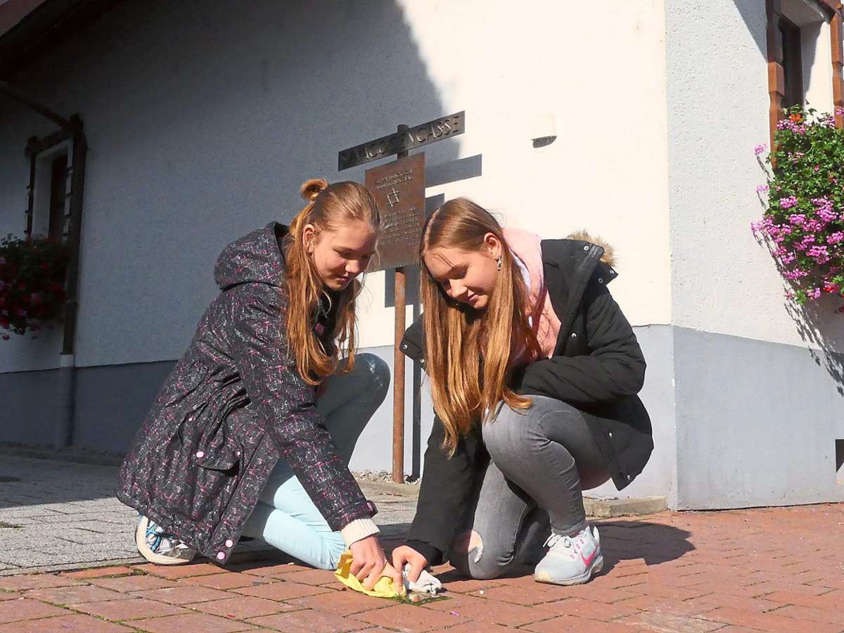 Die Schülerinnen Leonie und Maria  polieren den Stolperstein in der Lahrgasse. Dort stand einst die Synagoge.Fotos: Bohnert-Seidel