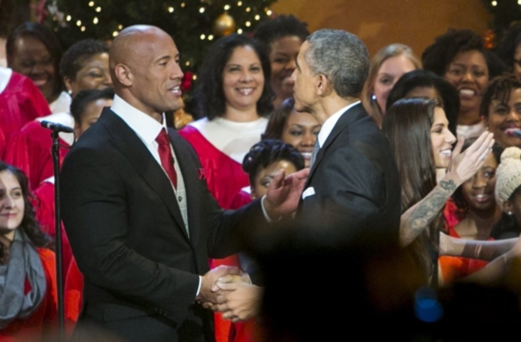 Barack Obama beim Weihnachtskonzert in washington mit dem Schauspieler Dwayne Johnson, auch bekannt als The Rock (links). Foto: SIPA POOL