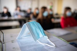 Ein Mund- und Nasentschutz liegt im Unterricht auf einem Ordner. Ab Montag werden die Schüler vielerorts selbst entscheiden können, ob sie im Klassenraum eine Maske tragen möchten, oder nicht. (Symbolfoto) Foto: Matthias Balk