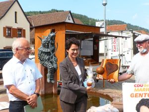 Eine Holzskulptur mit einem Herz und einer kleinen Weltkugel überreichte Julius Benz  der neuen Justizministerin Marion Gentges – das gefiel auch Harald Günther (links). Foto: Vögele