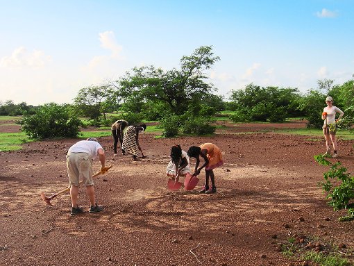 Zusammen anpacken: Afrikaner und Deutsche kratzen Kies vom Boden, um an dieser Stelle neue Klassenzimmer zu bauen. Foto: Verein