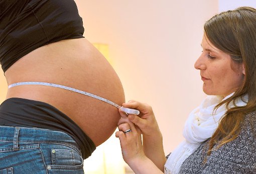 Eine Hebamme bei der Untersuchung einer schwangeren Frau. Foto: dpa/Hiekel Foto: Schwarzwälder-Bote