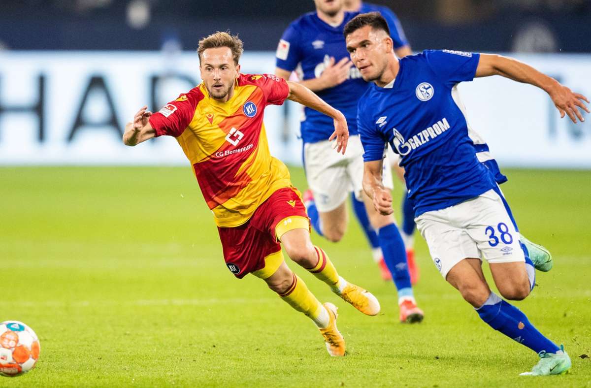 Lucas Cueto von Karlsruhe und Schalkes Mehmet Can Aydin verfolgen den Ball. Foto: dpa/Marcel Kusch