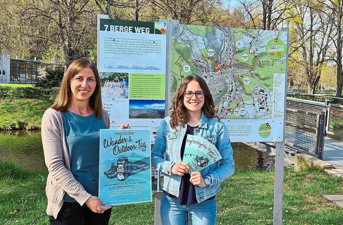 Sarah Leutner (links, Sachgebietsleiterin Tourismus der Stadt Nagold) und Annika Tittjung (Mitarbeiterin im Sachgebiet Tourismus der Stadt Nagold) präsentieren das Plakat und die Flyer zum Nagolder Wander- & Outdoortag