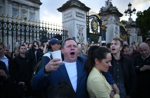 Vor dem Buckingham Palace singen Trauernde noch einmal „God save our gracious Queen“. Foto: AFP/DANIEL LEAL