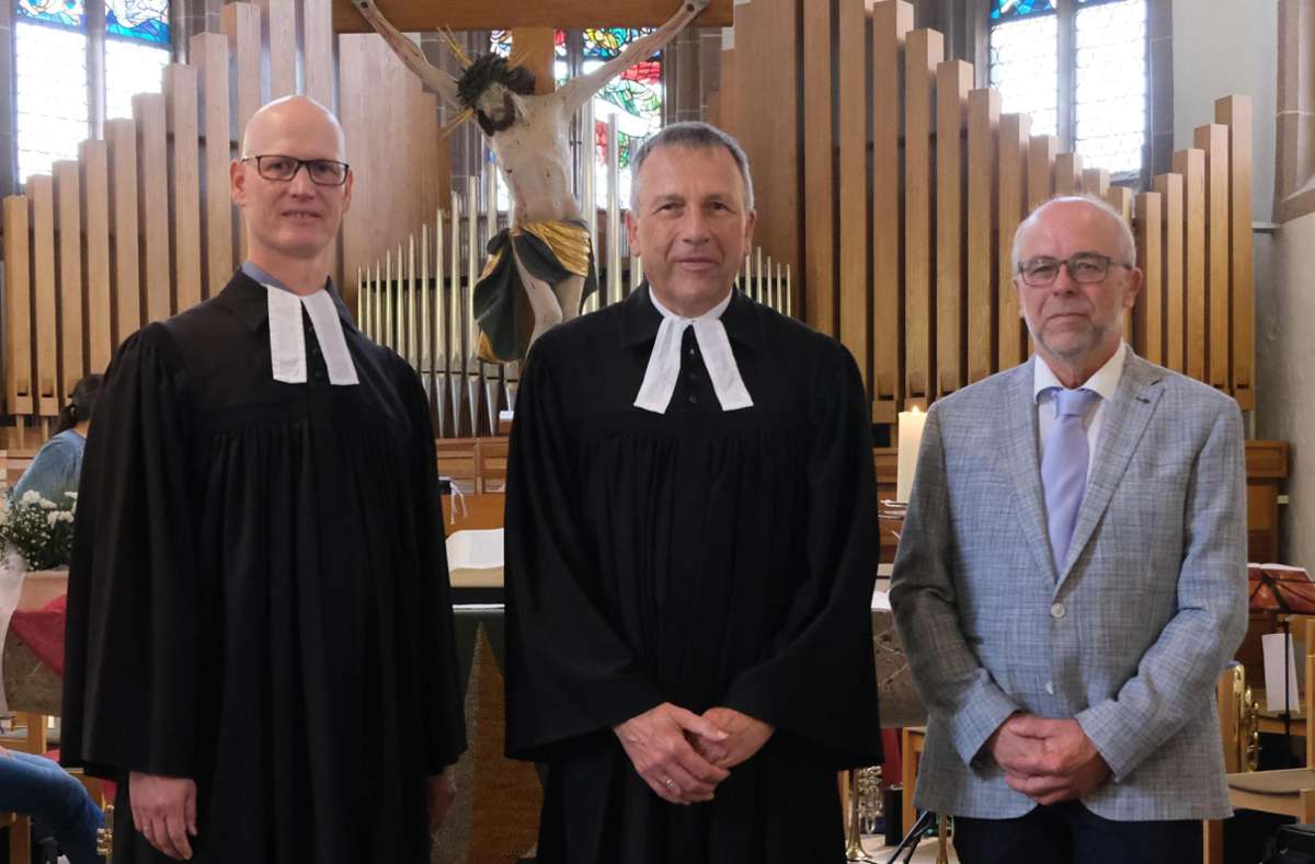 Pfarrer Johannes Unz (links) und Werner Kraibühler vom Kirchengemeinderat (rechts) verabschieden Pfarrer Hansjörg Landenberger in den Ruhestand.