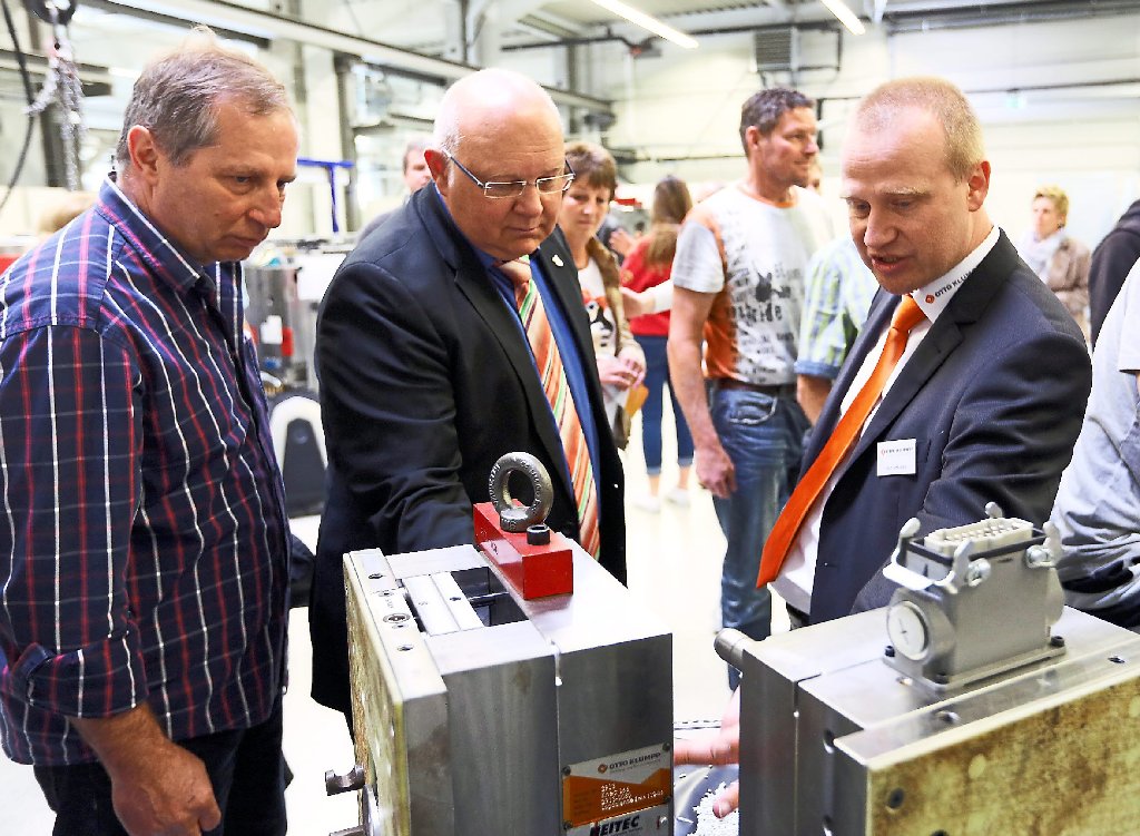 Da schau her: Berthold Roller und Helmut Reitemann lassen sich von Firmenchef Martin Klumpp (von links) ein Spritzgusswerkzeug erläutern, das Kunststoffteile für den Autohersteller Volvo produziert. Foto: Maier