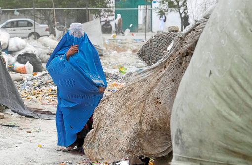 Eine Frau, die eine Burka trägt, geht vor ihrem Haus. Die in Afghanistan regierenden militant-islamistischen Taliban haben Frauen vorgeschrieben, in der Öffentlichkeit einen Ganzkörperschleier zu tragen. Foto: Noroozi/dpa