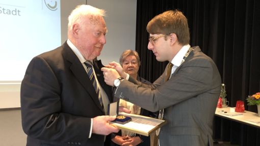 Gold für einen der wertvollsten Ehrenamtlichen: Bürgermeister Davide Licht zeichnet Friedemann Mutschler mit Medaille und Anstecknadel aus. Foto: Rapthel-Kieser