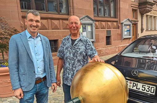 Bürgermeister Thomas Geppert (links) begutachtet die goldene Kugel, die Hans Peter Lythje bearbeitet hat. Foto: Fischer